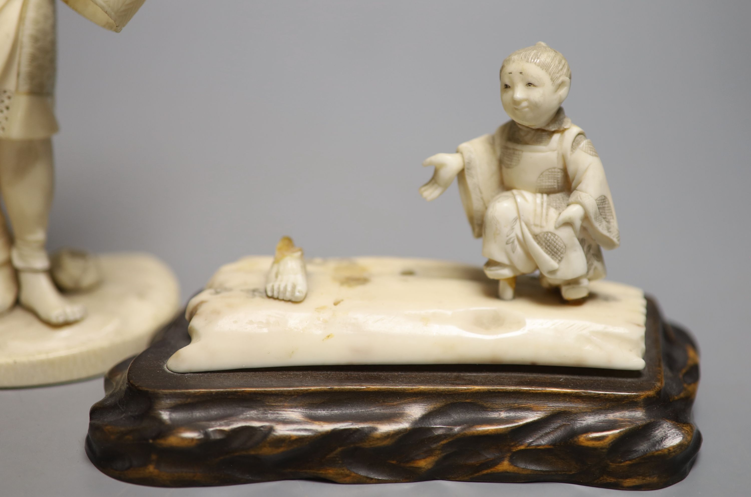 A Japanese Meiji period sectional carved ivory of a man, height 23cm and a Meiji ivory group (damaged)